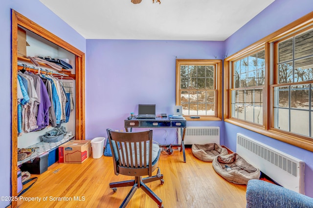 office area featuring hardwood / wood-style flooring and radiator heating unit