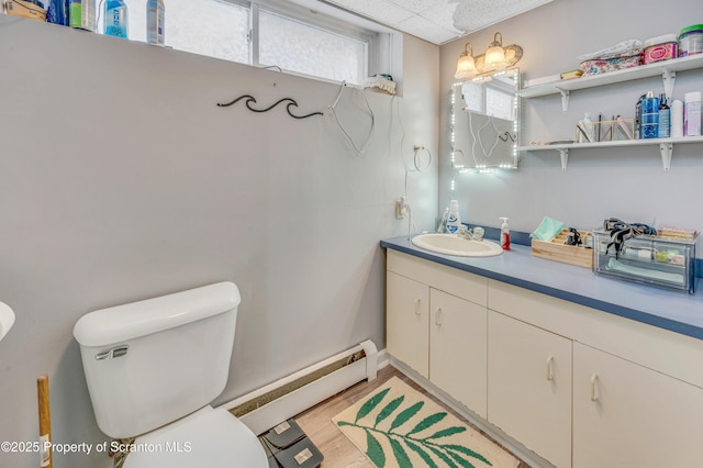 bathroom featuring vanity, wood-type flooring, a baseboard radiator, and toilet