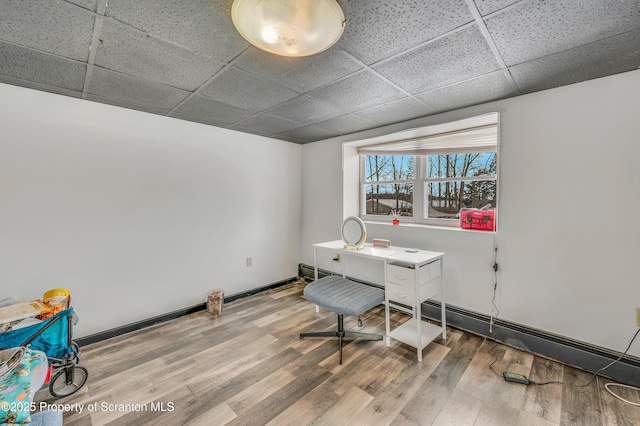 office space with hardwood / wood-style flooring and a paneled ceiling