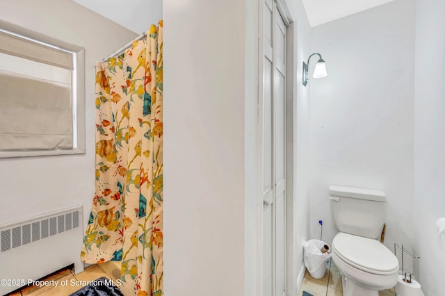 bathroom featuring tile patterned floors, radiator heating unit, and toilet