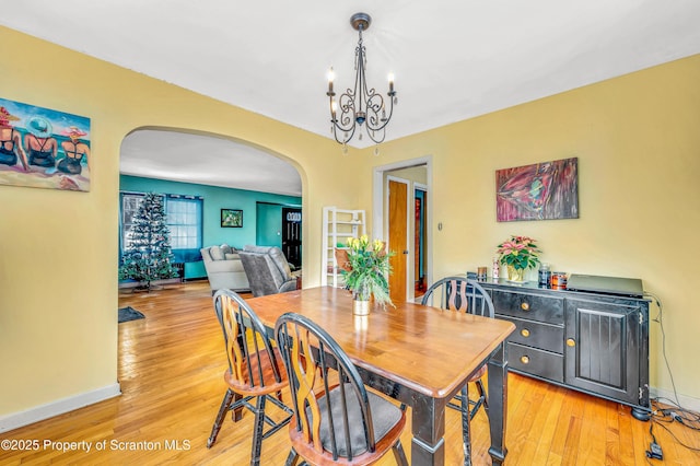 dining space featuring an inviting chandelier and light wood-type flooring