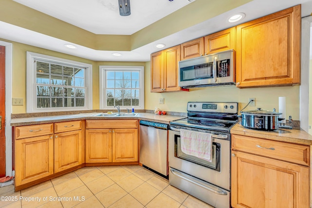 kitchen featuring sink, stainless steel appliances, a raised ceiling, and light tile patterned flooring