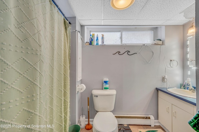 bathroom featuring vanity, baseboard heating, toilet, a drop ceiling, and a shower with shower curtain