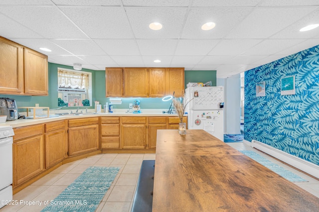 kitchen featuring stove, light tile patterned floors, a paneled ceiling, and white refrigerator