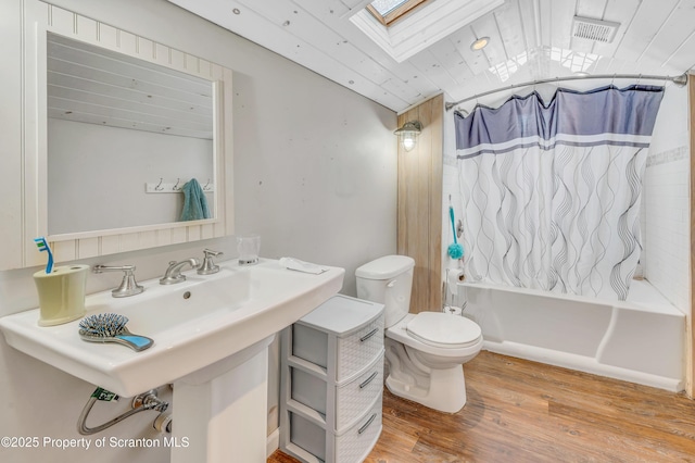 bathroom with wood ceiling, hardwood / wood-style flooring, shower / tub combo, a skylight, and toilet