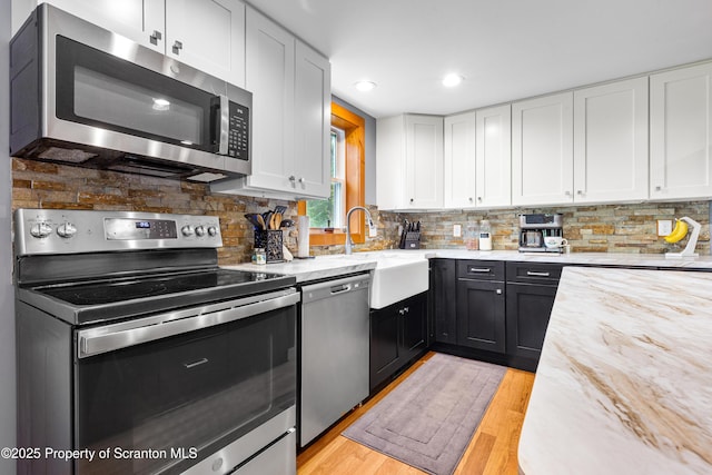 87 Old Farm Ln, White Haven, PA 18661 - kitchen featuring stainless steel appliances, white cabinetry, light wood-style floors, decorative backsplash, and recessed lighting