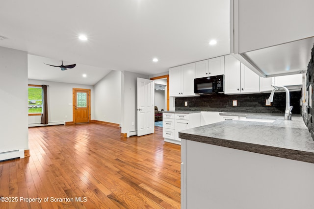 87 Old Farm Ln, White Haven, PA 18661 - kitchen featuring black microwave, a sink, decorative backsplash, white cabinets, and baseboard heating