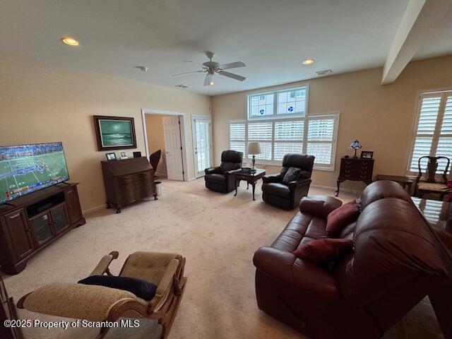 carpeted living room featuring plenty of natural light and ceiling fan