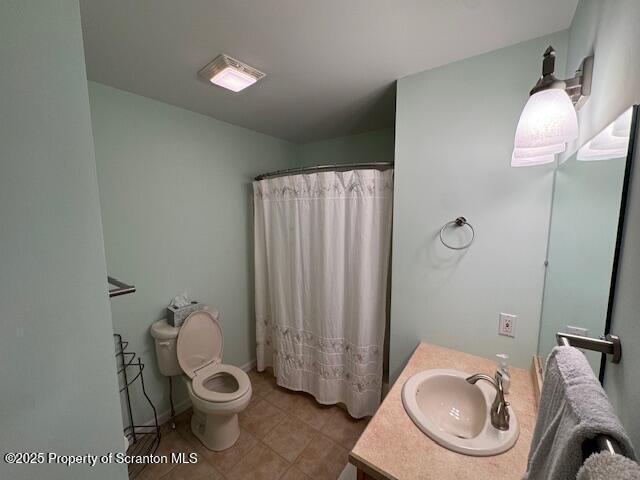 bathroom featuring vanity, walk in shower, and toilet