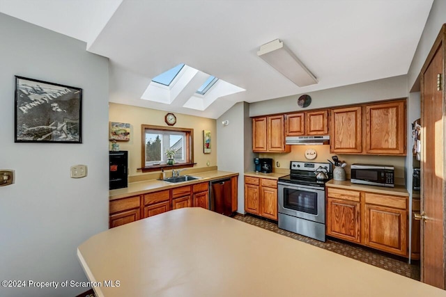 kitchen with lofted ceiling with skylight, sink, and stainless steel appliances