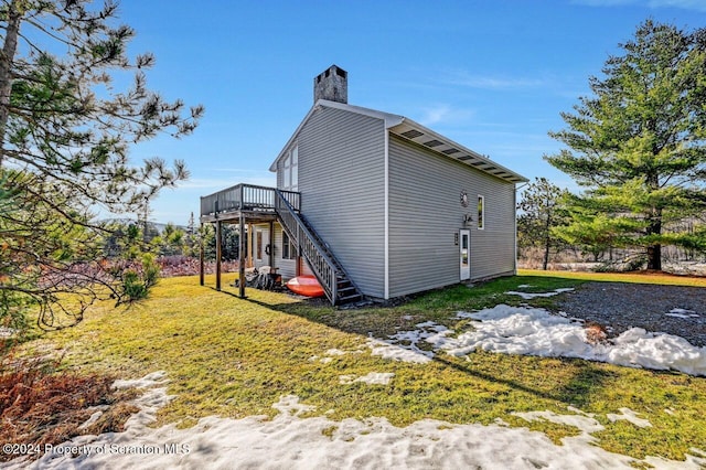 view of home's exterior featuring a lawn and a deck