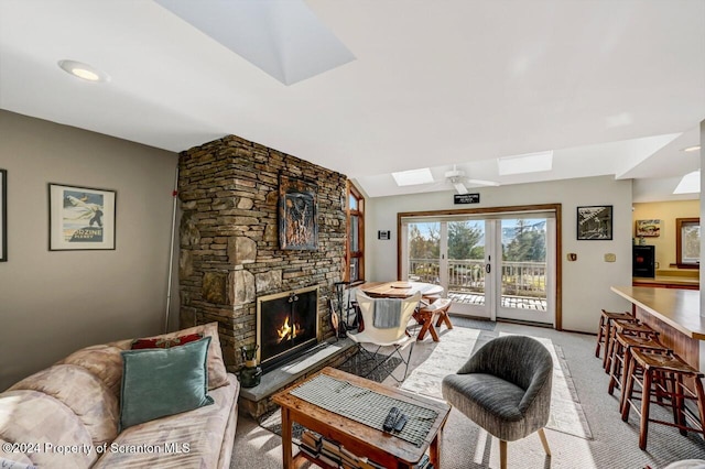 carpeted living room featuring ceiling fan and a fireplace