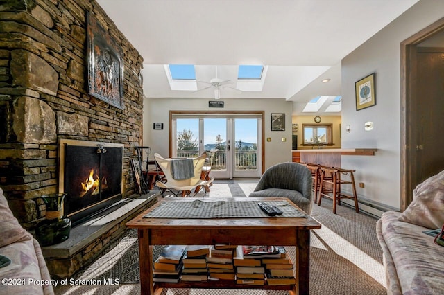 carpeted living room with ceiling fan, a fireplace, and a baseboard heating unit