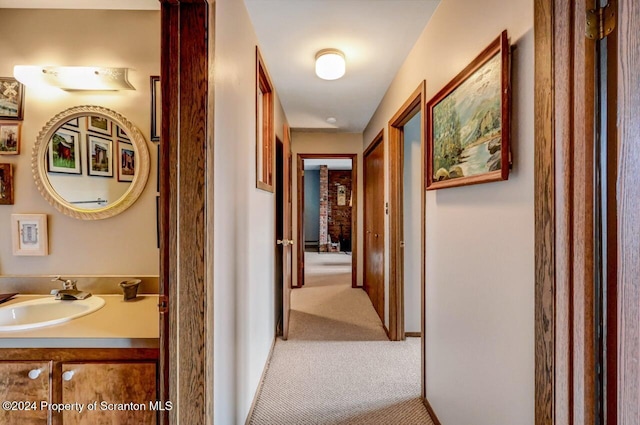 hall featuring carpet flooring and sink