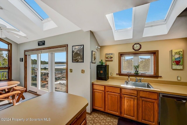 kitchen featuring dishwasher, lofted ceiling with skylight, ceiling fan, and sink