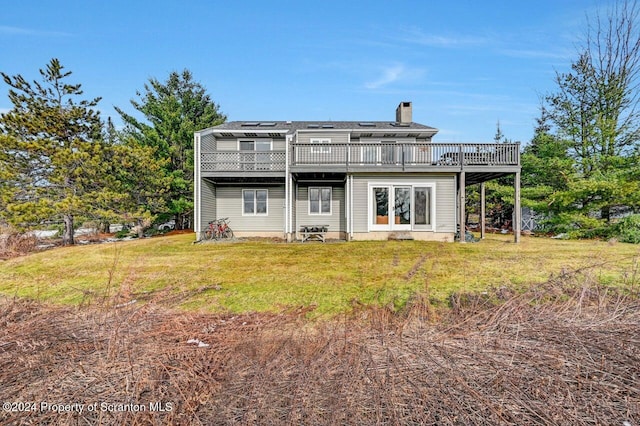 back of property with a wooden deck and a yard