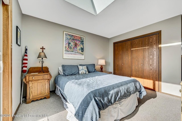 carpeted bedroom featuring a skylight and a closet