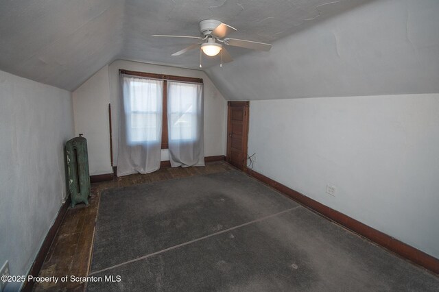 additional living space with baseboards, vaulted ceiling, wood finished floors, and a ceiling fan