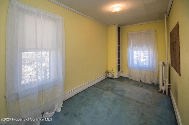 empty room featuring ornamental molding, radiator heating unit, baseboards, a baseboard heating unit, and carpet