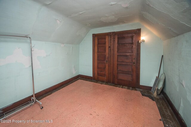 additional living space featuring baseboards and lofted ceiling