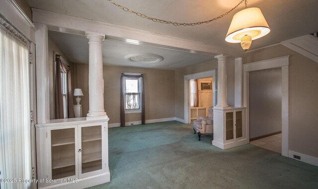interior space featuring baseboards, decorative columns, and carpet floors