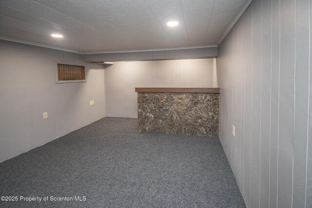 finished basement featuring a bar, ornamental molding, carpet, and recessed lighting