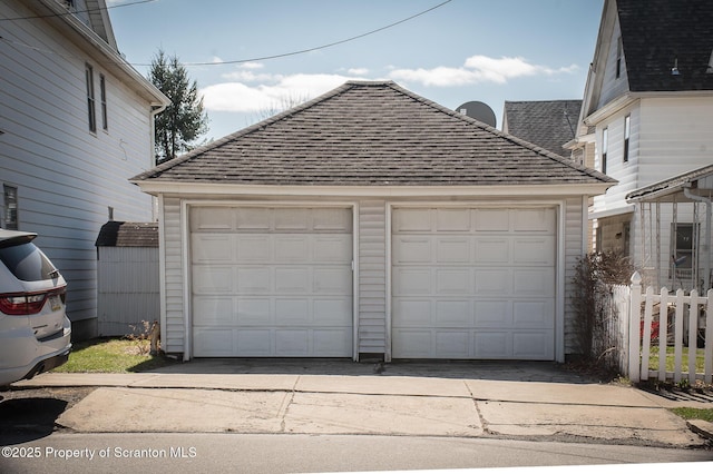 detached garage featuring fence