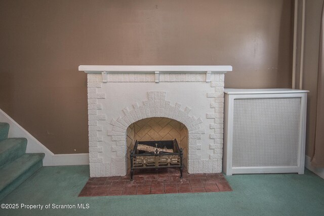 interior details featuring a fireplace with flush hearth, carpet flooring, and baseboards