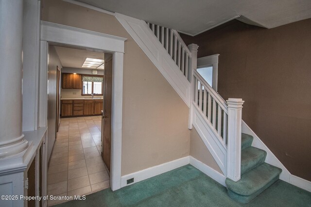 stairway with carpet flooring, tile patterned floors, and baseboards
