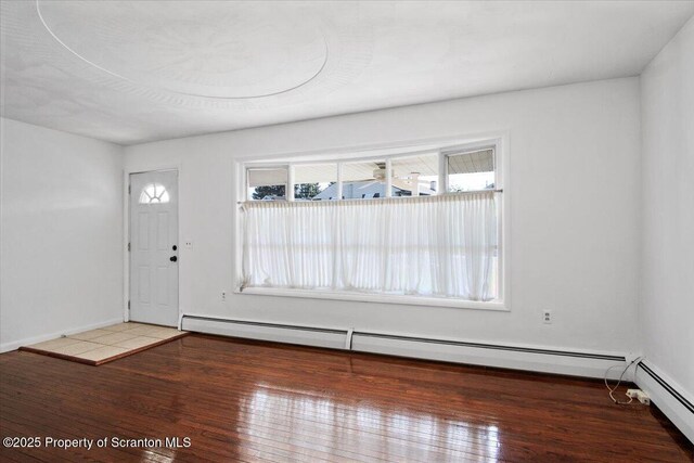 foyer featuring a baseboard radiator, wood finished floors, and baseboards