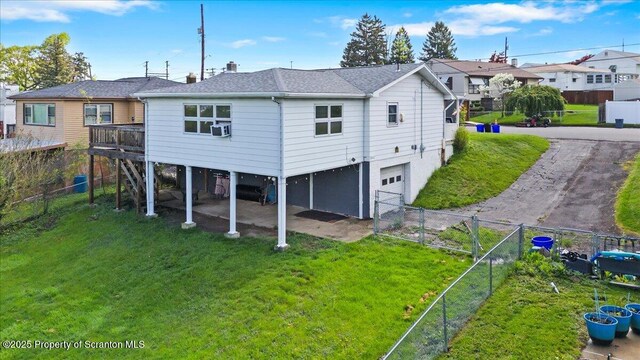 rear view of house featuring an attached garage, a residential view, and driveway