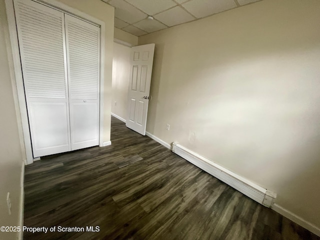 1211 Jackson St 1209-, Scranton, PA 18504 - unfurnished bedroom with a baseboard heating unit, a paneled ceiling, baseboards, dark wood finished floors, and a closet