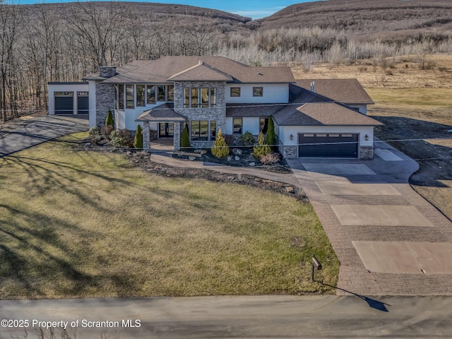 815 Oak St, Archbald, PA 18403 - view of front facade featuring a front yard, concrete driveway, a garage, stone siding, and a mountain view