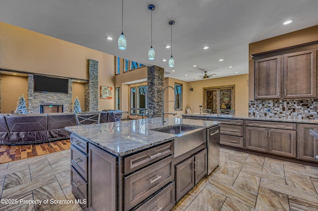 815 Oak St, Archbald, PA 18403 - kitchen featuring a ceiling fan, a sink, stainless steel dishwasher, open floor plan, and a fireplace