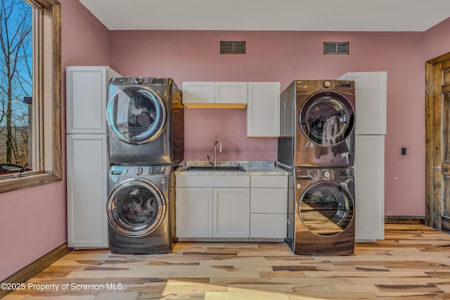 815 Oak St, Archbald, PA 18403 - laundry area with light wood-style floors, visible vents, cabinet space, and stacked washer / drying machine