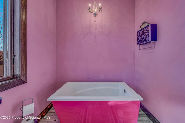 815 Oak St, Archbald, PA 18403 - bathroom with a tub, baseboards, an inviting chandelier, and wood finished floors