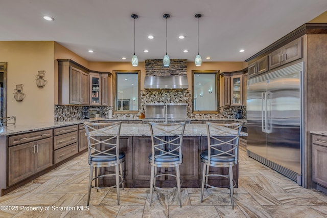 815 Oak St, Archbald, PA 18403 - kitchen featuring a kitchen bar, a center island, glass insert cabinets, and stainless steel built in fridge