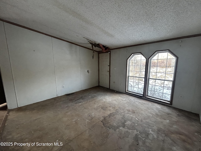 unfurnished room featuring a textured ceiling and crown molding