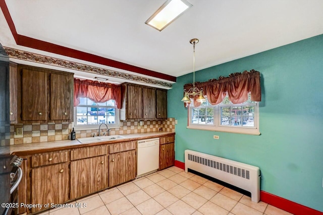 kitchen featuring sink, decorative light fixtures, radiator heating unit, dishwasher, and stove