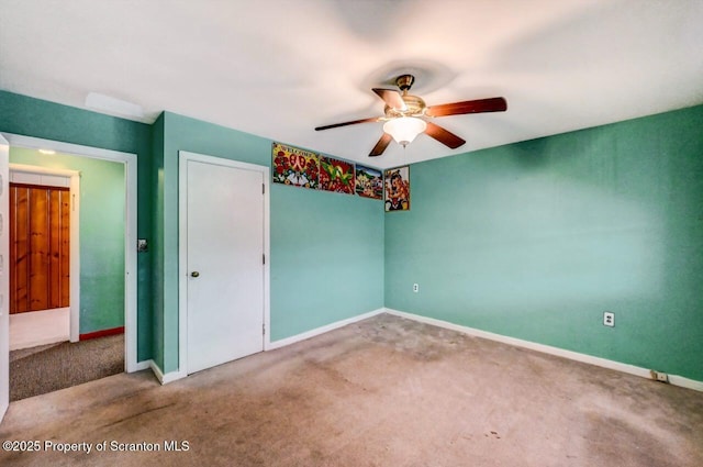 carpeted spare room with ceiling fan