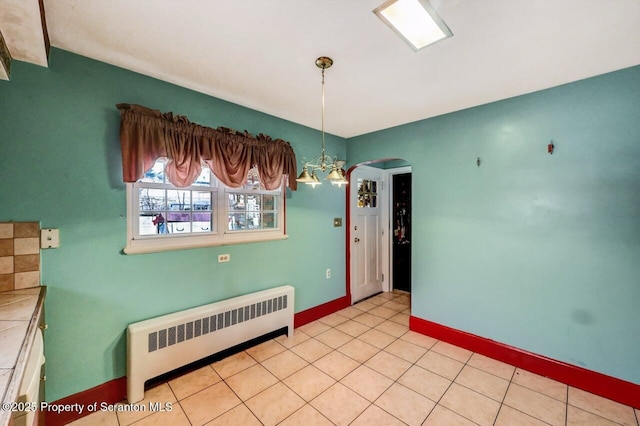 unfurnished dining area with radiator and light tile patterned floors