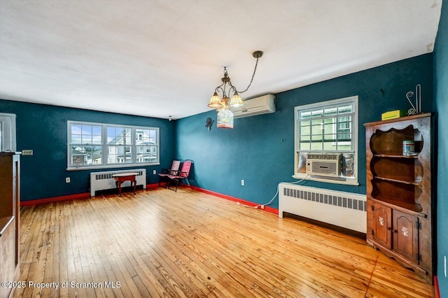 misc room with a wall mounted AC, plenty of natural light, radiator, and light hardwood / wood-style flooring