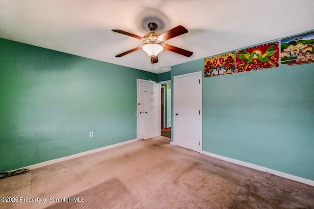 spare room with ceiling fan and carpet