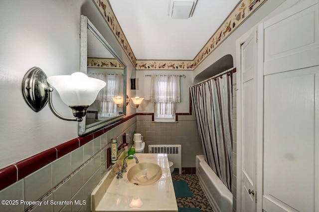 bathroom featuring tile walls, vanity, radiator heating unit, and shower / bath combination with curtain