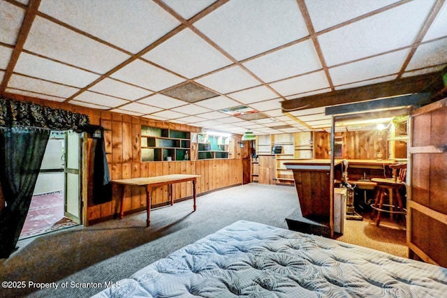 bedroom featuring indoor bar, wooden walls, and carpet flooring