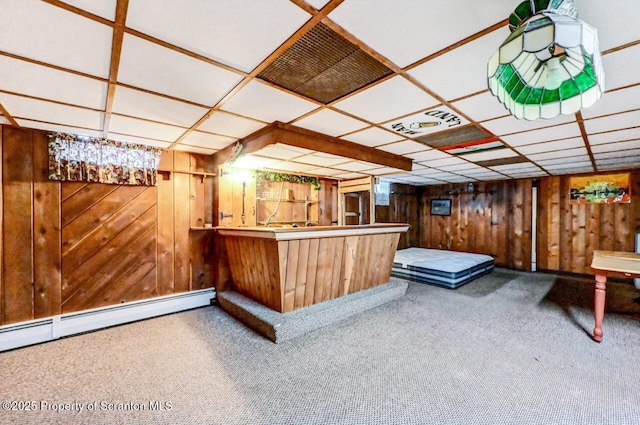 bar featuring a drop ceiling, a baseboard heating unit, carpet floors, and wooden walls