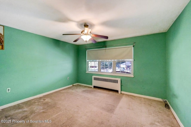 carpeted spare room featuring radiator heating unit and ceiling fan