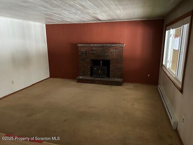 unfurnished living room featuring a baseboard heating unit and carpet