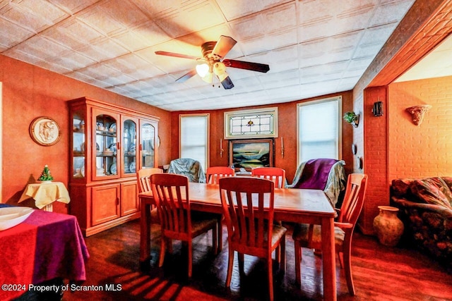 dining area with ceiling fan, brick wall, and dark hardwood / wood-style floors