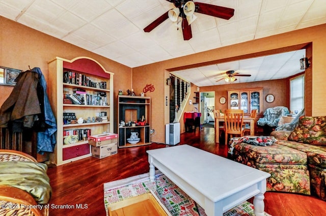 living room with dark wood-type flooring and ceiling fan